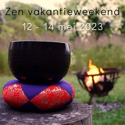 zwarte meditatiebel op een kleurig kussen, op de achtergrond een vuurkorf