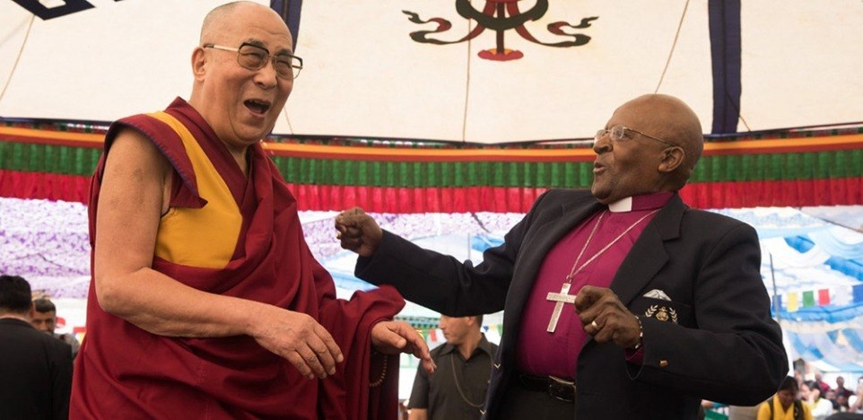 de Dalai Lama en Desmond Tutu staan samen te lachen